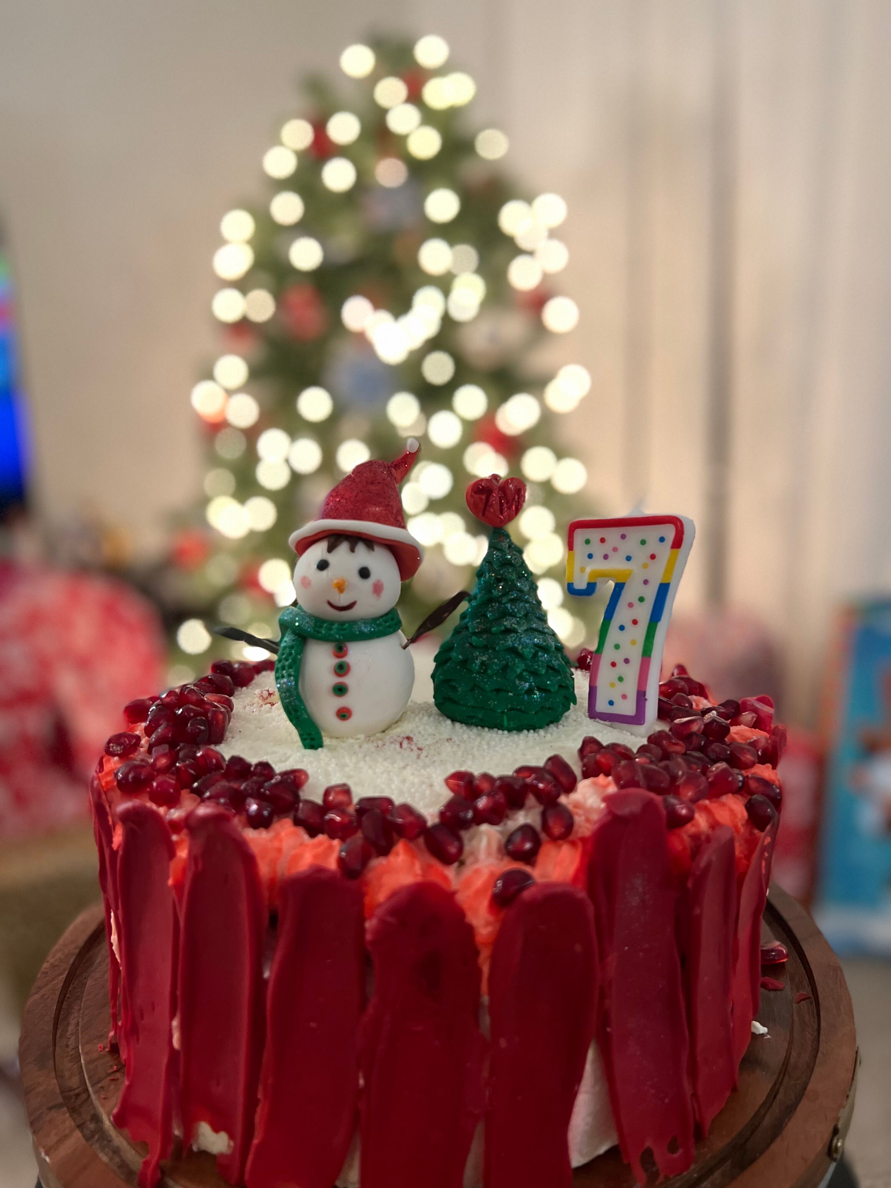 A cake decorated with a snowman and a christmas tree.